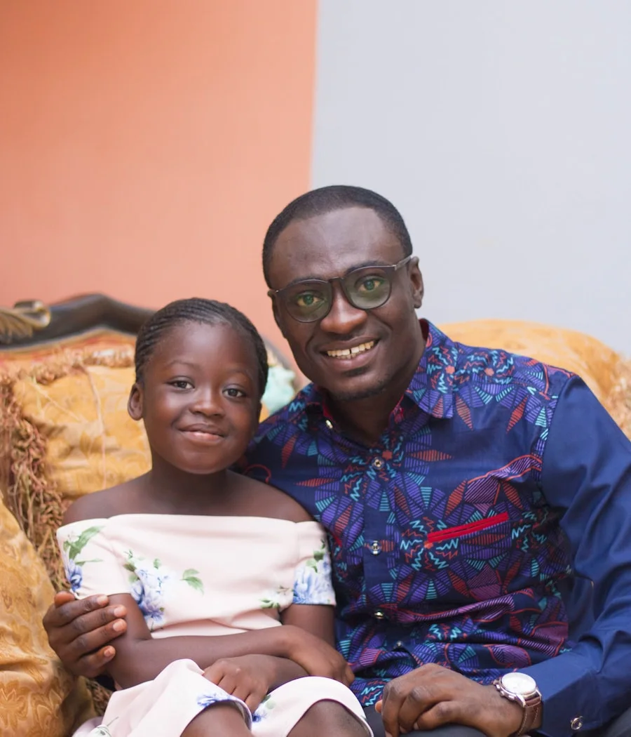 Her father carrying her, laughing together in Accra