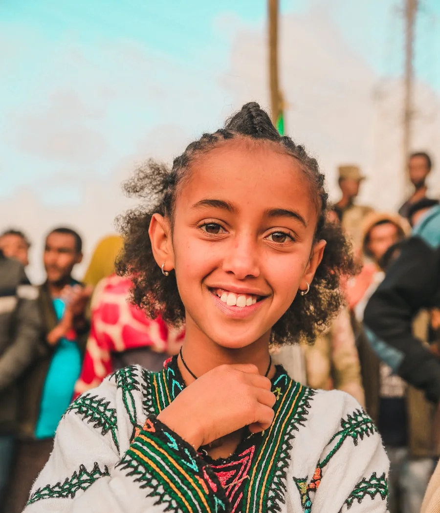 His little sister in traditional dress, smiling in Addis Ababa