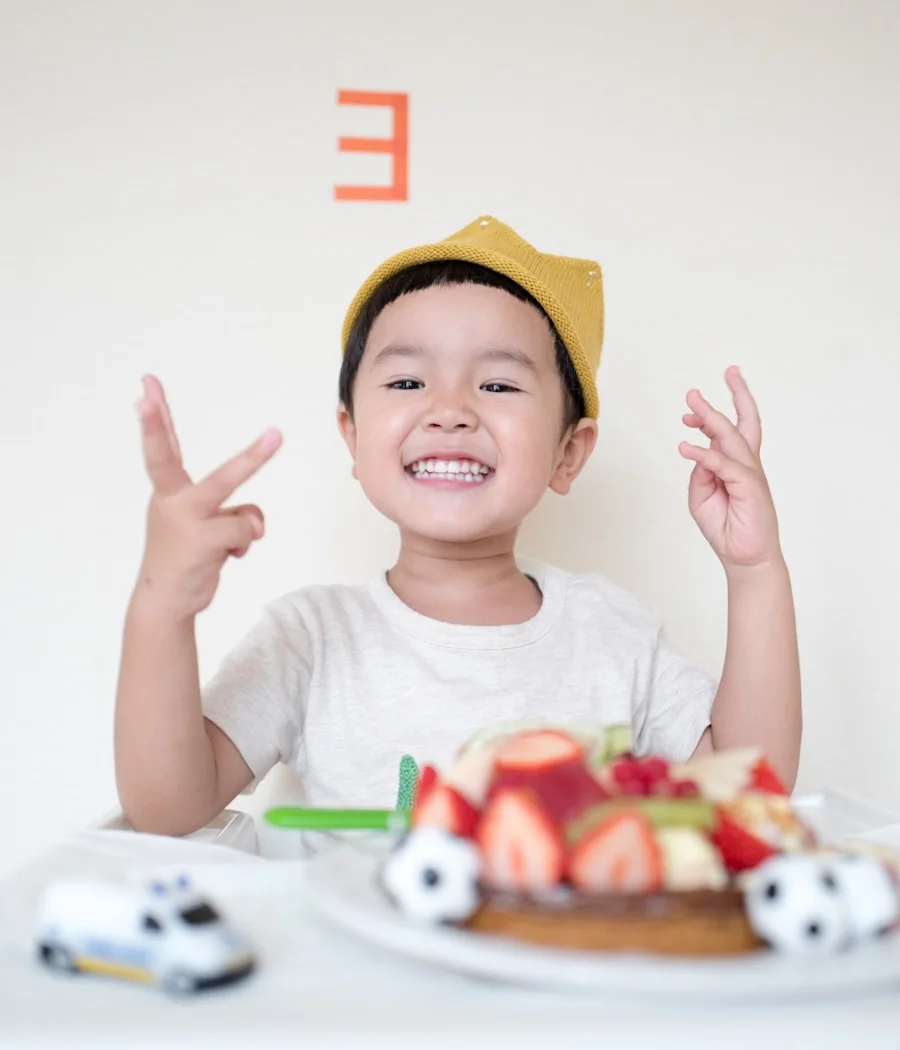 His son celebrating his birthday with cake and a new toy in Manila